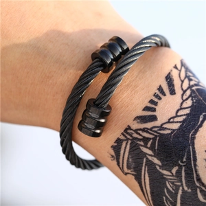 Close-up van een zwarte roestvrijstalen kabelarmband voor heren met getextureerde eindkap