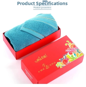 Blue cotton face towel with gold trim in a decorative red gift box, overhead detail view