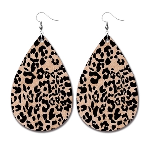 Macro detail of leopard print teardrop earrings with silver metal hooks on white background