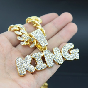 Macro detail of gold-plated iced out KING pendant with sparkling clear crystals