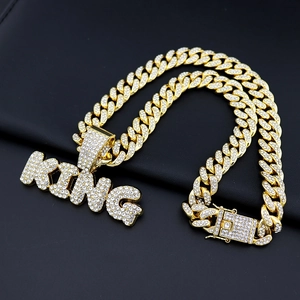 Close-up of golden King letter pendant with diamonds on hip hop Cuban link necklace