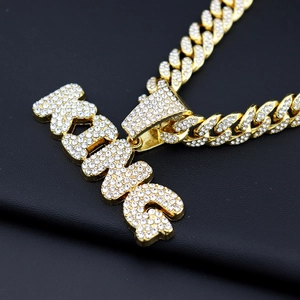 Hip hop gold Cuban link chain with sparkling diamond KING letter pendant on black background