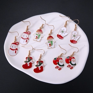 Christmas alloy earrings set featuring snowman, Santa, and festive charms on a white tray