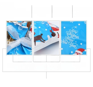 Detail of Christmas drawstring gift bag showing the ribbon closure and festive reindeer patterns