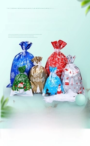 Detail of colorful Christmas drawstring gift bags with Santa and snowman patterns
