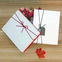 Close-up of elegant gift boxes with 'Thank You' tag and ribbon on wooden surface