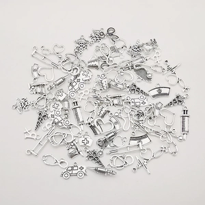 Detailed macro view of silver-tone medical charms like stethoscope and nurse hat