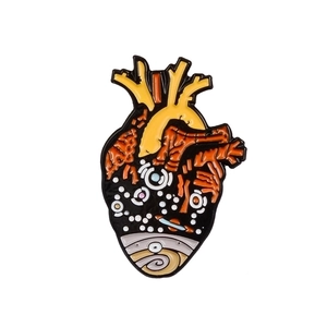 Detailed macro view of an anatomical heart enamel pin with vibrant yellow and blue colors