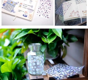 Close-up of pastel star and polka dot washi stickers on a journal and glass bottle