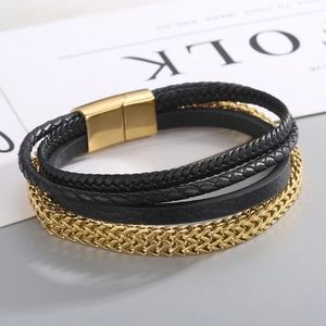Close-up of multilayer black woven leather bracelet with gold chain and magnetic clasp