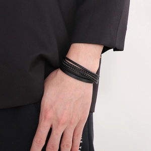 Detail of multi-layer black leather woven bracelet with stainless steel magnetic clasp
