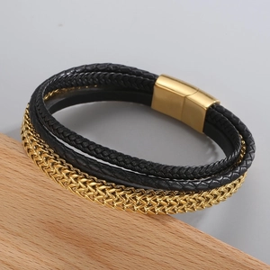 Close-up of braided black leather layers and a golden wheat chain with magnetic clasp