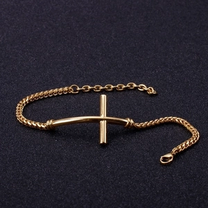 Elegant gold cross bracelet for men made of stainless steel on a black textured background