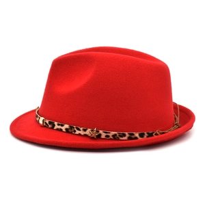 Close-up of red felt fedora with leopard print band and gold star pendant detail