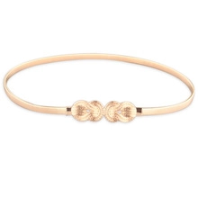 Close-up of golden metal spring belt with decorative interlocking double round buckle