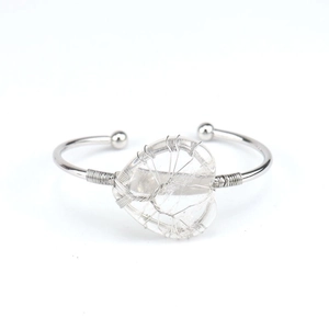 Macro shot of silver wire wrapped tree of life on heart crystal on a flexible bangle