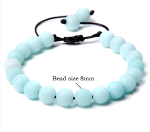 Detail view of 8mm natural light blue stone beads on an adjustable braided cord bracelet