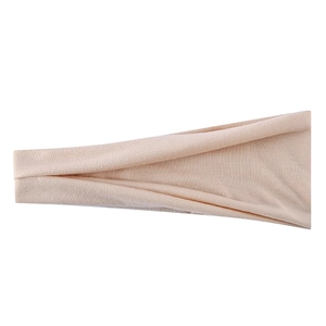 Close-up of peach elastic yoga headband showing fine ribbed knit fabric texture details