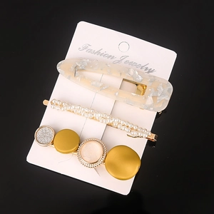 Close-up of a 3-piece hair clip set with resin glitter, pearls, and gold metal accents