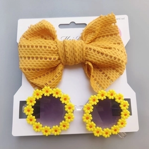 Detail of yellow daisy sunglasses with purple lenses and hollow out bow headband