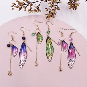 Detailed view of colorful gradient cicada wing earrings with heart pendants and gold hooks