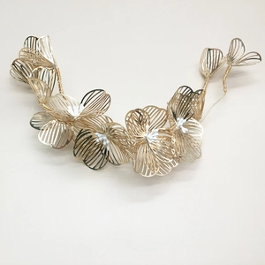 Detailed view of handmade gold floral headband with white bead accents for wedding