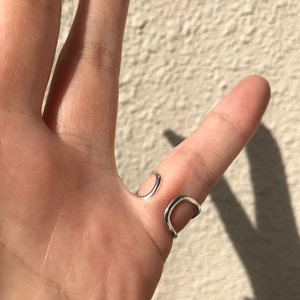 Minimalist 925 sterling silver geometric open ring shown on hand with side lighting