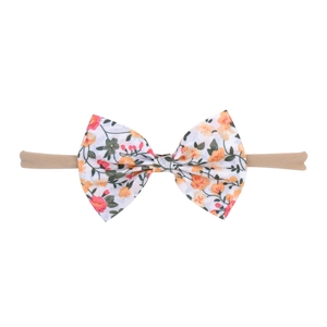 Detail of floral baby bow headband with pink flower patterns on nude elastic band