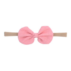 Detailed view of pink fabric bow headband with elastic texture and seamless soft band