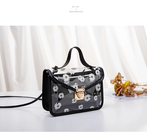 Close-up of transparent daisy print PVC handbag with black trim and gold metal buckle