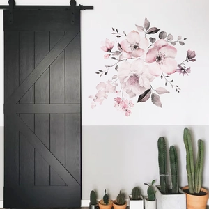 Watercolor pink floral wall decals applied next to a black barn door and potted cactus