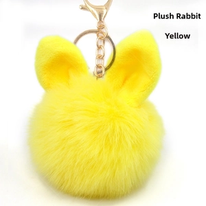 Detail of yellow plush rabbit ear pompom keychain with golden zinc alloy clasp