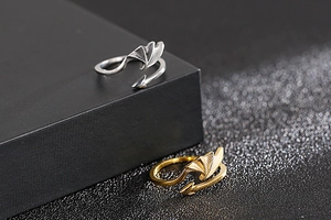 Macro shot of polished gothic devil wing and arrow open rings in gold and silver finish