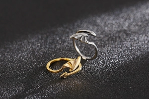 Macro detail of dragon wing and arrow tip adjustable rings in gold and silver finish