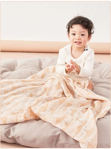 Detail of soft beige muslin swaddle blanket with wave patterns for newborn babies