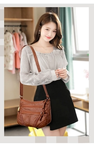 Brown soft leather crossbody bag with multiple zip pockets and woven side details