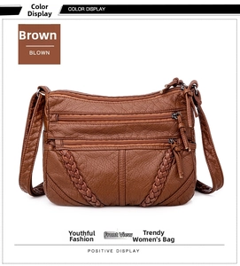 Detailed view of a brown crossbody bag with litchi texture and woven trim details