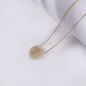 Golden round cross pendant necklace with clear cubic zirconia on white background