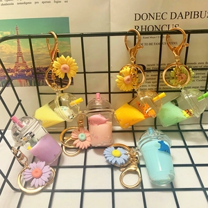 Detailed set of colorful acrylic boba milk tea keychains in a black wire mesh basket