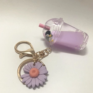 Close-up of acrylic milk tea keychain with purple liquid and a mini penguin floating charm