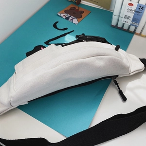 Detailansicht der weißen Segeltuch-Brusttasche mit schwarzem Reißverschluss und Gurt