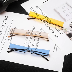 Three pairs of narrow rimless rectangular sunglasses in yellow, brown, and blue lenses