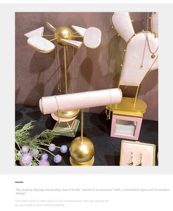Detail of pink velvet jewelry display stands with gold metal frames for earrings and necklaces