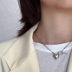 Macro shot of a silver 3D heart pendant necklace with OT toggle clasp on model