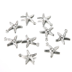 Set of nine silver stainless steel starfish pendants with small rings on white background