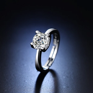 Detail of a four-prong set round moissanite ring with adjustable silver-colored band