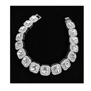 Detailed view of silver-tone link bracelet with square crystals and pavé halo accents