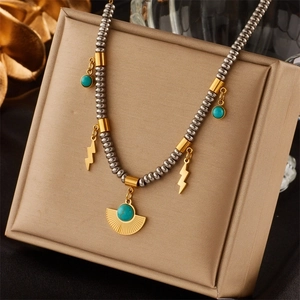 Detail of vintage turquoise pendant necklace with gold accents on a soft display cushion