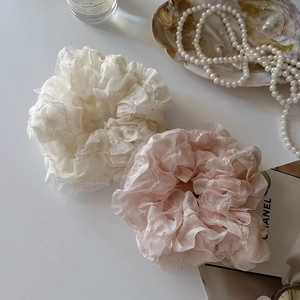 Lacy oversized scrunchies in cream and pink on a minimalist aesthetic desktop