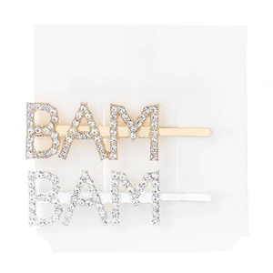 Close-up of sparkling rhinestone BAM letter hair clips in gold and silver finish